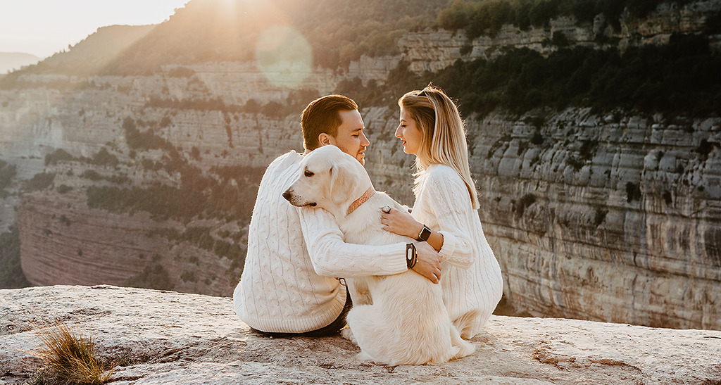 Vlad and Nastya with a dog sitting on the top of rock