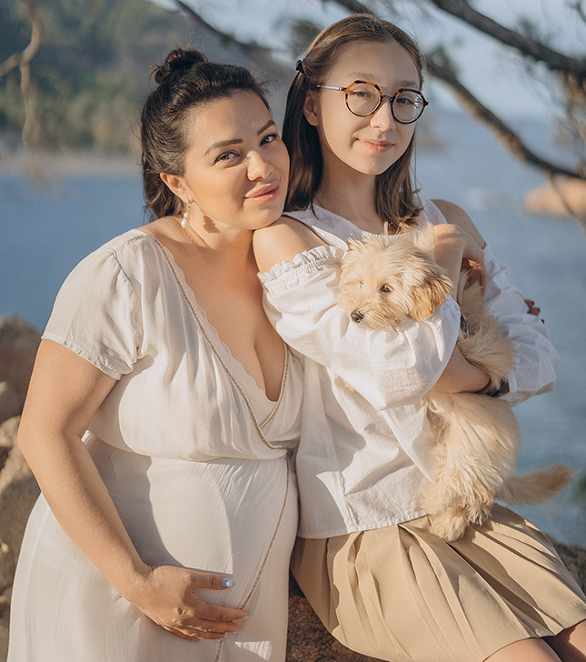 Pregnant woman with daughter and dog